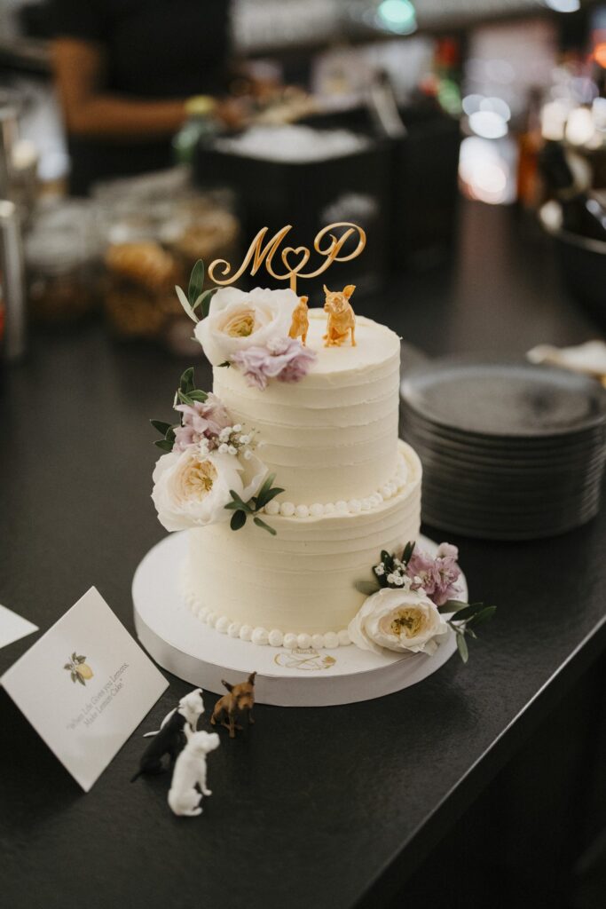 Hochzeitstorte mit goldenem Cake-Topper und Blumen