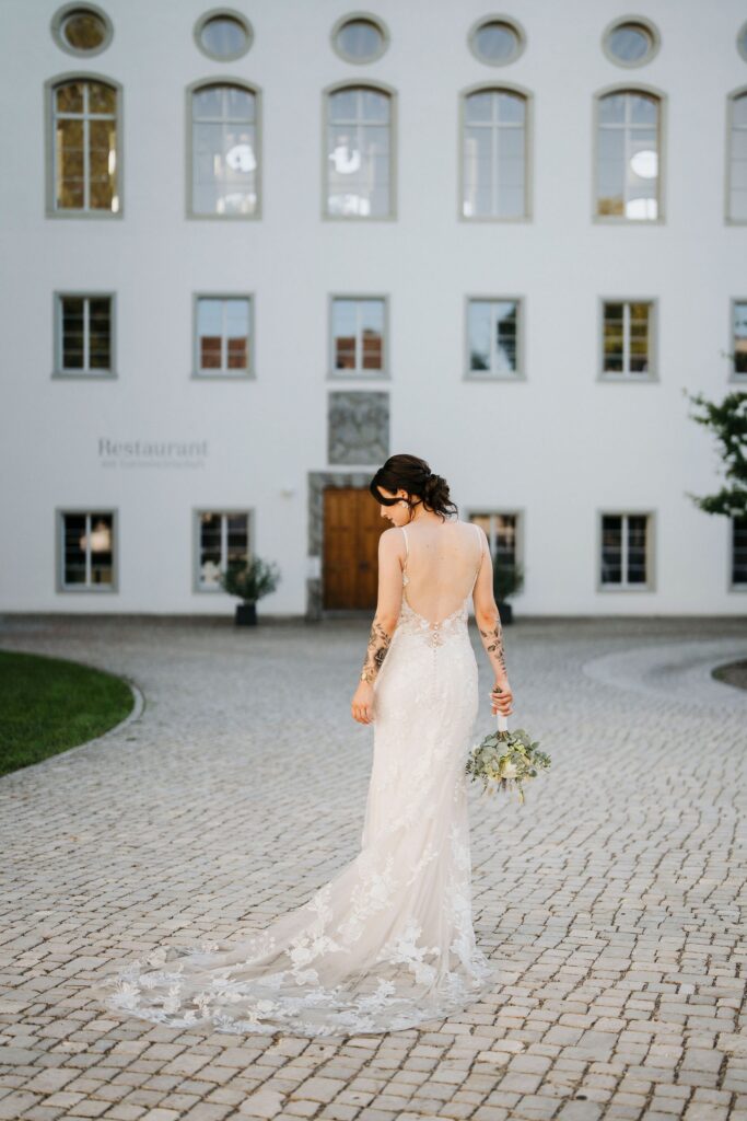 Braut mit Schleppe vor dem Kloster